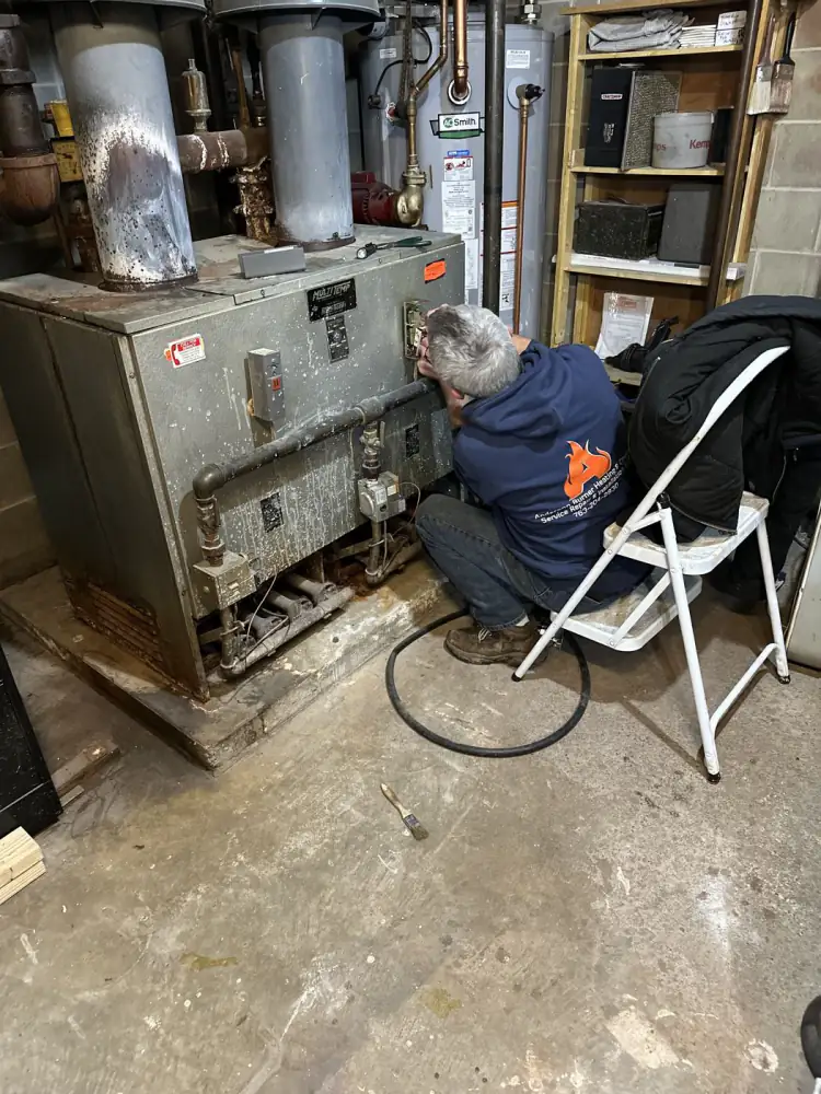 Anderson Burner technician servicing an older oil furnace